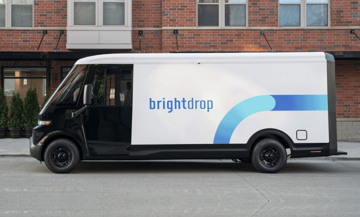 Vue latérale d’une fourgonnette électrique GM BrightDrop stationnée devant un bâtiment.