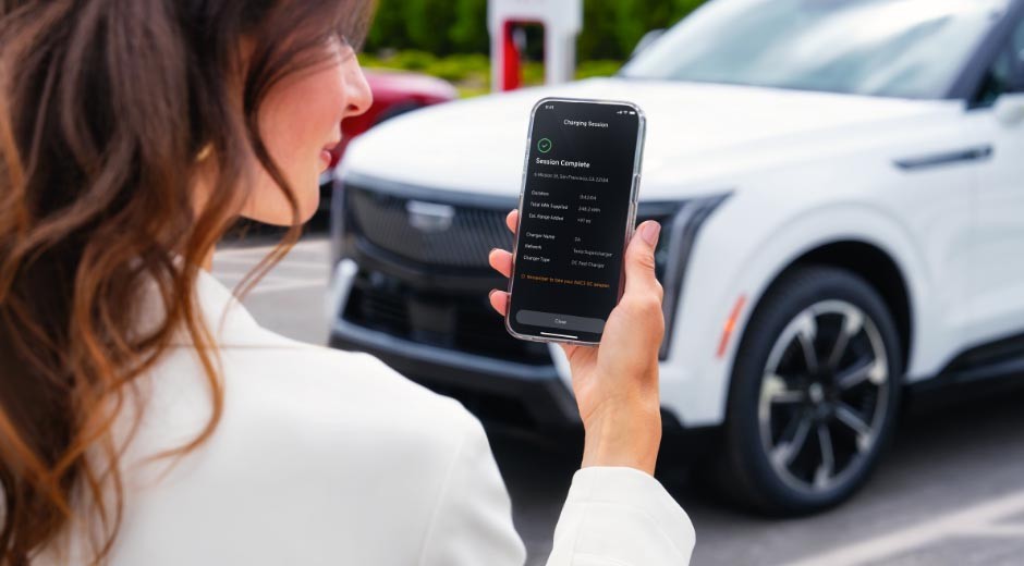 Une femme souriante qui utilise l'application mobile myCadillac sur iPhone